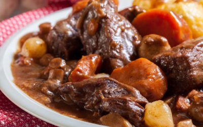 Beef Bourguignon stew served with baked potatoes on a plate. French cuisine